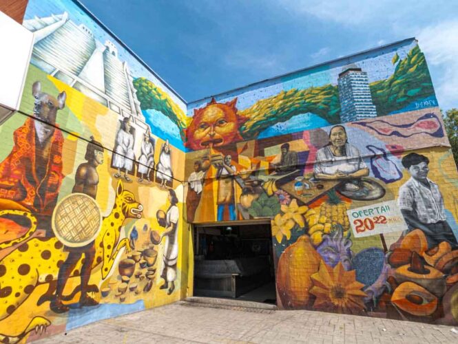 Colorful Mexico City street art depicting a mix - prehispanic Mexico and people that work in the mercado, selling fruit, vegetables, and prepared foods.