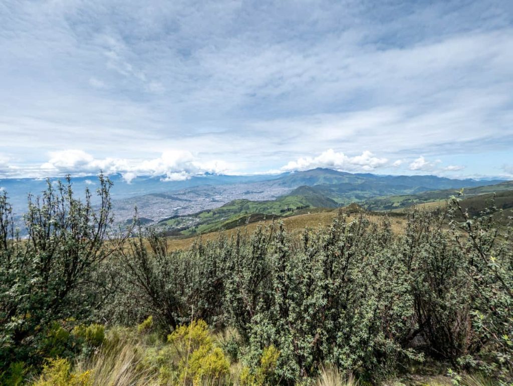 Sweeping view of Quito and the surrounding green mountains from high above, captured along the trail accessed via the cable car in Quito.